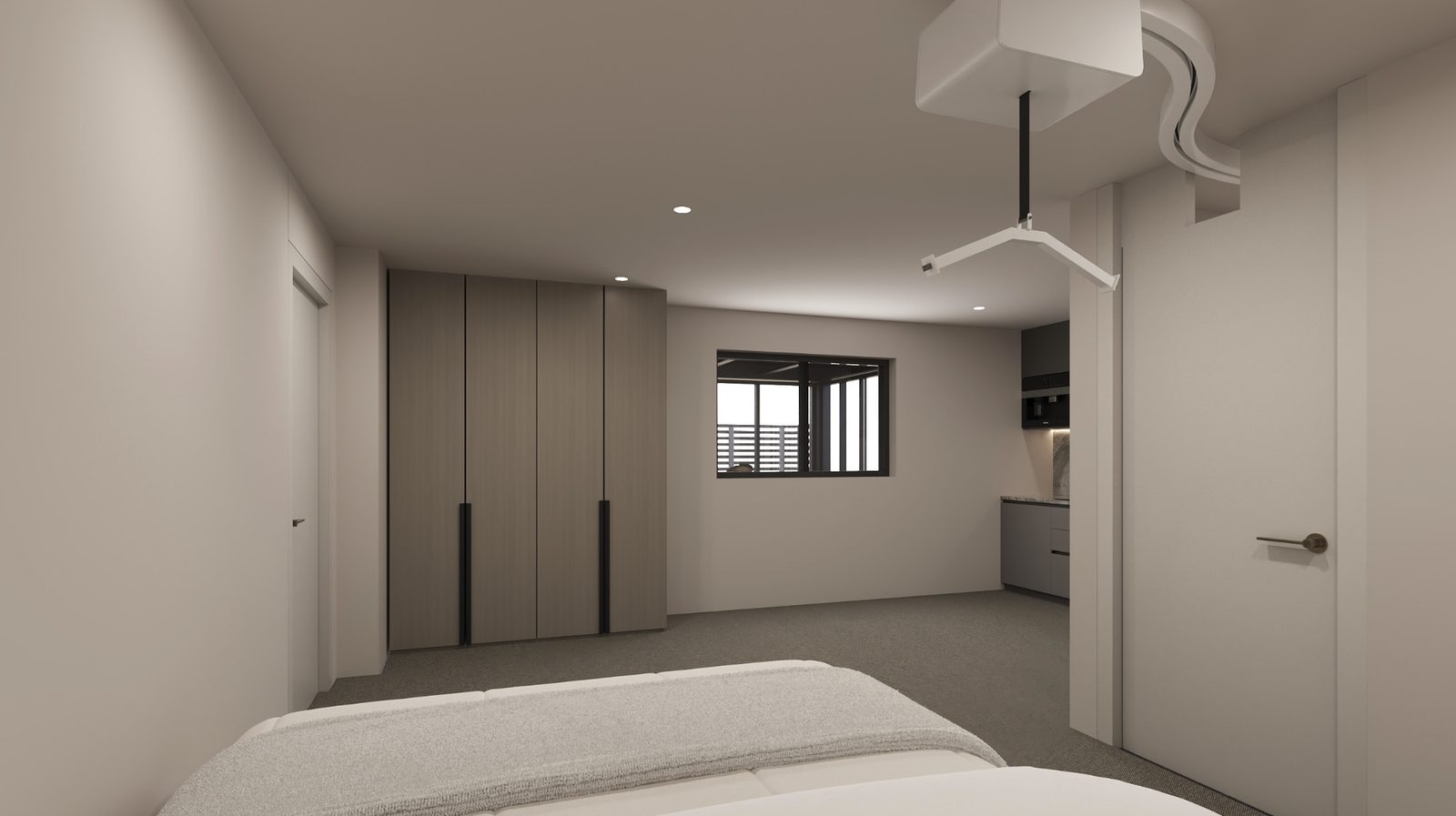 A studio seen from the bed, with full-height wardrobes, a window and the kitchen area beyond.